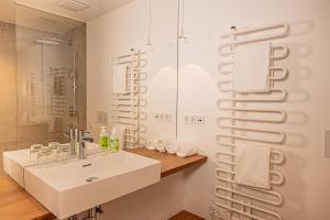 a white bathroom with a sink and a shower at Luxus-Apartements direkt am Attersee in Seewalchen