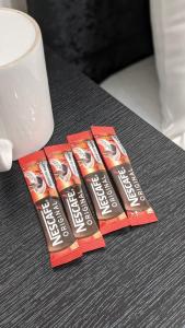 a group of three packs of toothpaste sitting on a table at Cosy Rooms in Ilford