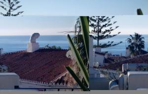 a view of the roofs of buildings with the ocean at 3 Bedroom Awesome Home In Nerja in Nerja
