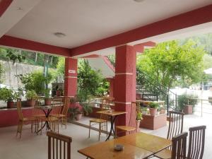 a patio with tables and chairs in a restaurant at Hotel Flora in Çorovodë