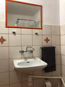 ein Bad mit einem Waschbecken und einem Spiegel in der Unterkunft Noclegi na Sudeckim in Świebodzice