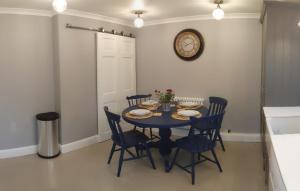 a dining room table with chairs and a clock on the wall at Pinewood Studios, Iver near Heathrow and Windsor XL 75sqm 2 King Bed Flat with 2 Parking Spaces in Buckinghamshire