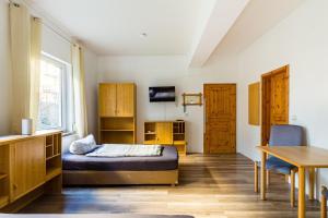 Schlafzimmer mit einem Bett, einem Schreibtisch und einem Tisch in der Unterkunft Apartmenthaus in Chemnitz für Monteure in Chemnitz