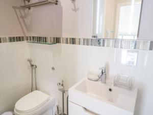 a white bathroom with a toilet and a sink at UpTown - Manhattan House in Llandudno +14 photos