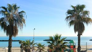 a view of a beach with palm trees and the ocean at LIDO Rooms & Apartments in Lido di Fermo