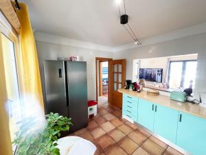 a kitchen with a stainless steel refrigerator and blue cabinets at The Yellow House in Paul do Mar