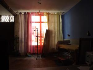 Zimmer mit einem Fenster und einem Tisch mit einem Stativ in der Unterkunft Lougat la maison des chats in Cordes-sur-Ciel