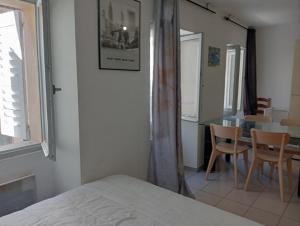 een slaapkamer met een bed, een tafel en stoelen bij T1 Vieux Port Opéra in Marseille