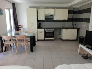 een keuken met witte kasten en een tafel en stoelen bij T1 Vieux Port Opéra in Marseille