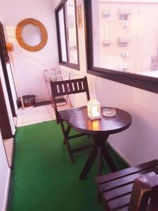 a table and chair in a room with a green floor at Résidences Hozy in Abidjan