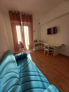 a living room with a blue couch and a table at Milly Rooms in Celle Ligure