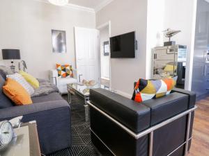 a living room with a couch and a chair at MidTown - Manhattan House in Llandudno