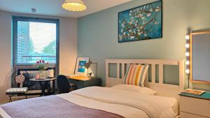 a bedroom with a bed and a desk and a window at A Stylish Flat Offering a Private Bedroom Near Landmark of Portsmouth in Portsmouth