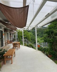 a patio with a table and chairs and a umbrella at Tainan House台南家 in Awaji
