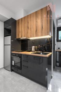 een keuken met zwarte apparatuur en houten kasten bij Railway Lofts, Nilie Hospitality MGMT in Thessaloniki