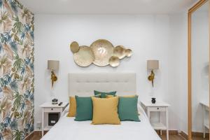 1 dormitorio con 1 cama con almohadas amarillas y verdes en Tirso Studio, en Madrid