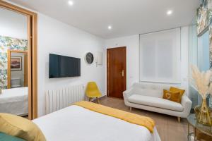 1 dormitorio con cama, sofá y TV en Tirso Studio, en Madrid