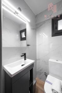 bagno bianco con lavandino e servizi igienici di Railway Lofts, Nilie Hospitality MGMT a Salonicco