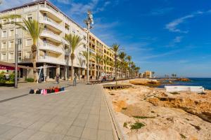 a building on the beach next to the ocean at ALEGRIA ID118 in Torrevieja