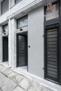 twee ingangen van een gebouw met zwarte deuren bij Railway Lofts, Nilie Hospitality MGMT in Thessaloniki