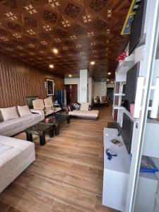 Nathia GaliにあるBlue sky Apartmentのソファとテレビ付きの広いリビングルーム