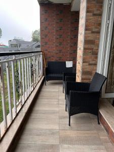 a balcony with two chairs and a railing at Blue sky Apartment in Nathia Gali