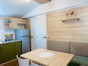 a small kitchen with a table and a refrigerator at Mobile home Comfort Jezera Murter in Jezera
