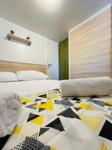 una camera da letto con un letto con un piumone di Mobile home Comfort Jezera Murter a Jezera