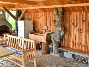 eine Blockhütte mit einem Kamin, einem Tisch und einer Bank in der Unterkunft APARTMA JAKOPIČ in Zgornje Gorje