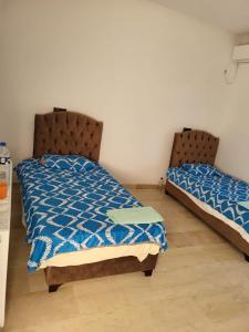 dwa łóżka siedzące obok siebie w sypialni w obiekcie Villa Smiley w Hammamet