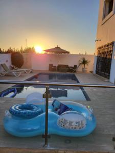 una piscina con una barca blu gonfiabile di fronte alla piscina di Villa Smiley a Hammamet