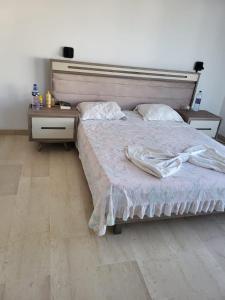a bedroom with a bed with a headboard and two night stands at Villa Smiley in Hammamet