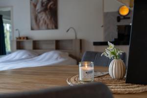 a candle on a table next to a bed at De Vrijheid-Plantage in De Cocksdorp