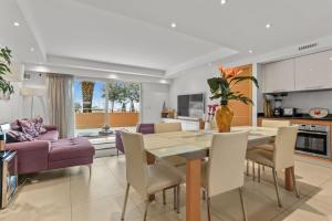 a kitchen and living room with a table and chairs at Chic & Modern 2 Bed Apartment in Théoule-sur-Mer with Pool Access & Beach Proximity in Théoule-sur-Mer