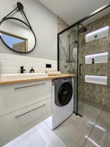 uma máquina de lavar roupa na casa de banho com um espelho em 34_Boho - DeerRest Apart em Jelenia Góra