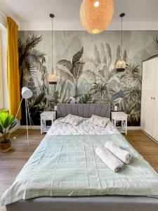 um quarto com uma cama grande e papel de parede tropical em 34_Boho - DeerRest Apart em Jelenia Góra