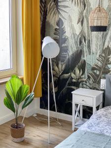 a bedroom with a plant and a wall mural at 34_Boho - DeerRest Apart in Jelenia Góra