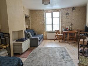 a living room with a couch and a table at Au bois radieux - option massage in Bellême