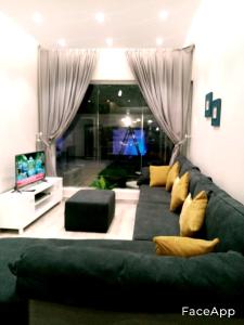 a living room with a green couch and a television at شاليهات z5 الفندقية in Al ‘Awājīyah