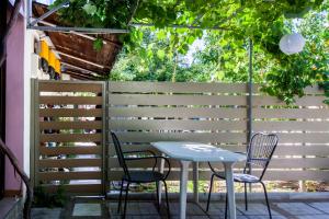 une table et des chaises sur une terrasse avec une clôture dans l'établissement Garden Guest Room, à Fanárion