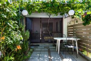 Garden Guest Room في فاناريون: فناء صغير مع طاولة بيضاء وكراسي