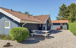 SpodsbjergにあるHoliday Home Drejet Rudkøbing Iiiの青い建物前のピクニックテーブル