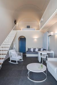 a living room with white furniture and a staircase at Acroterra Rosa Luxury Suites & Spa in Akrotiri