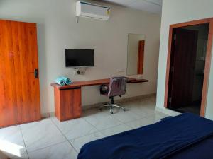 a bedroom with a desk with a television and a chair at Unique Couple Friendly Stay in Morbi