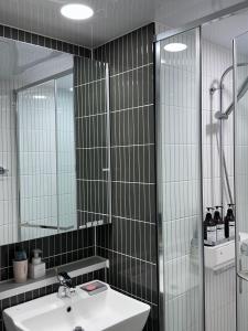 a bathroom with a sink and a shower and a mirror at Dongseongro Cozy House in Daegu