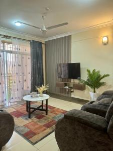 ein Wohnzimmer mit einem Sofa und einem TV in der Unterkunft Hillsview Apartment in Voi