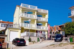 two cars parked in front of a building with balconies at Apartment Crikvenica, Vinodol 2 in Crikvenica