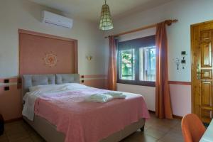 1 dormitorio con 1 cama con manta rosa y ventana en Garden Guest Room en Fanárion