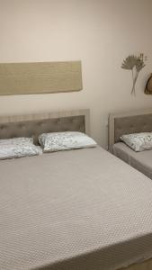 a bedroom with two beds with white sheets at Melody Apartament 1 in Golem