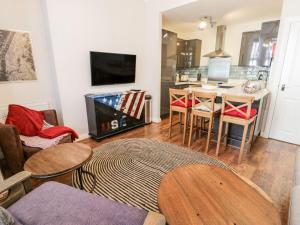 a living room with a table and a kitchen at DownTown - Manhattan House in Llandudno +20 photos